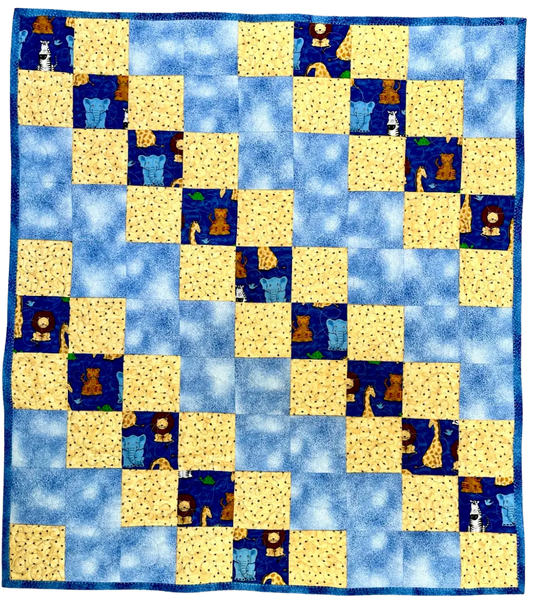 Patchwork quilt with blue and yellow squares featuring animal illustrations