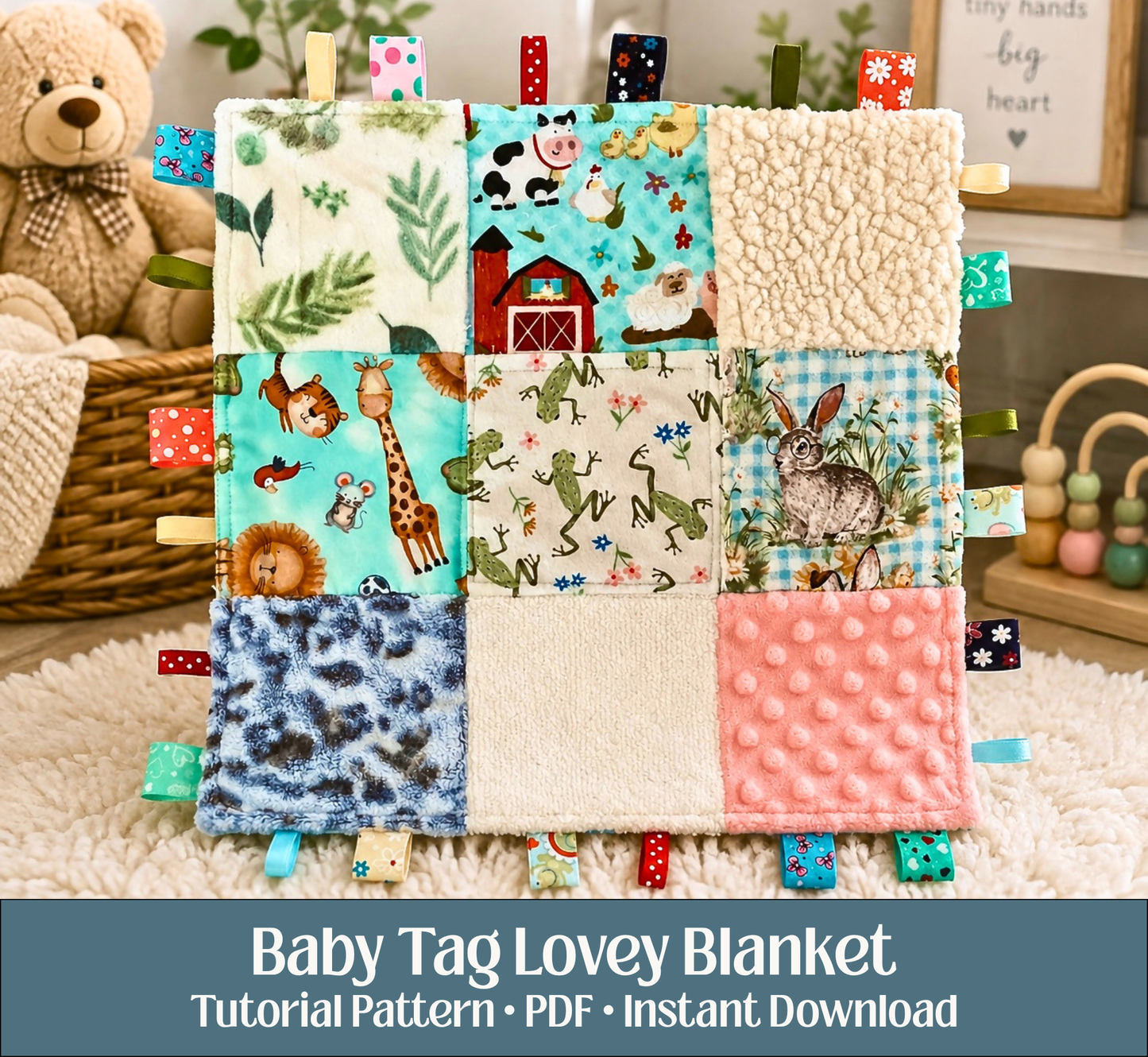 A baby lovey blanket made of patchwork fabric panels with animal and nature prints, sherpa fleece sections, and textured pink minky with ribbon tabs; a sensory toy for a baby. A teddy bear basket and wooden toy are blurred in the background.